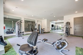 A home gym with exercise equipment and a bathtub